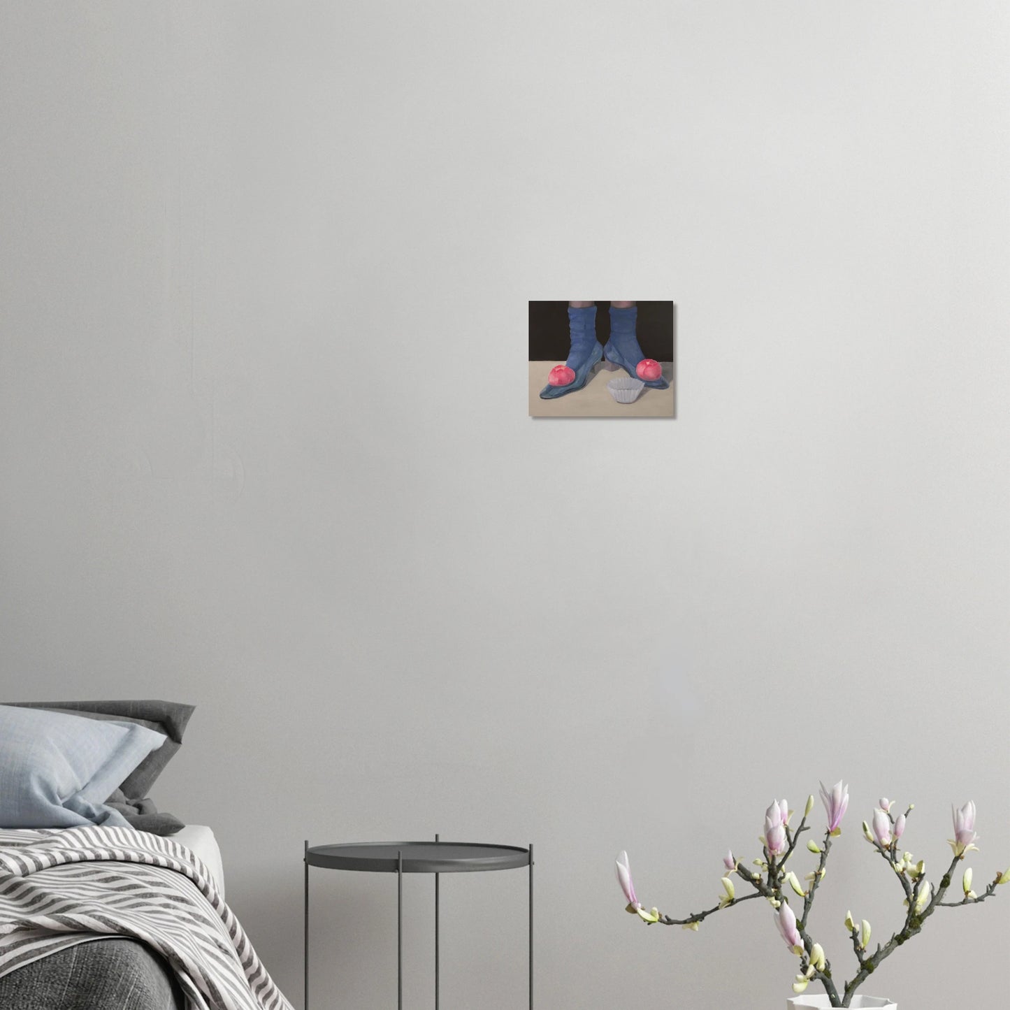 Jay Didyk's "I vanish ere the tea is done" painting against a bare grayish wall. Bed, nightstand, and potted magnolia on the lower quadrant of the photo.